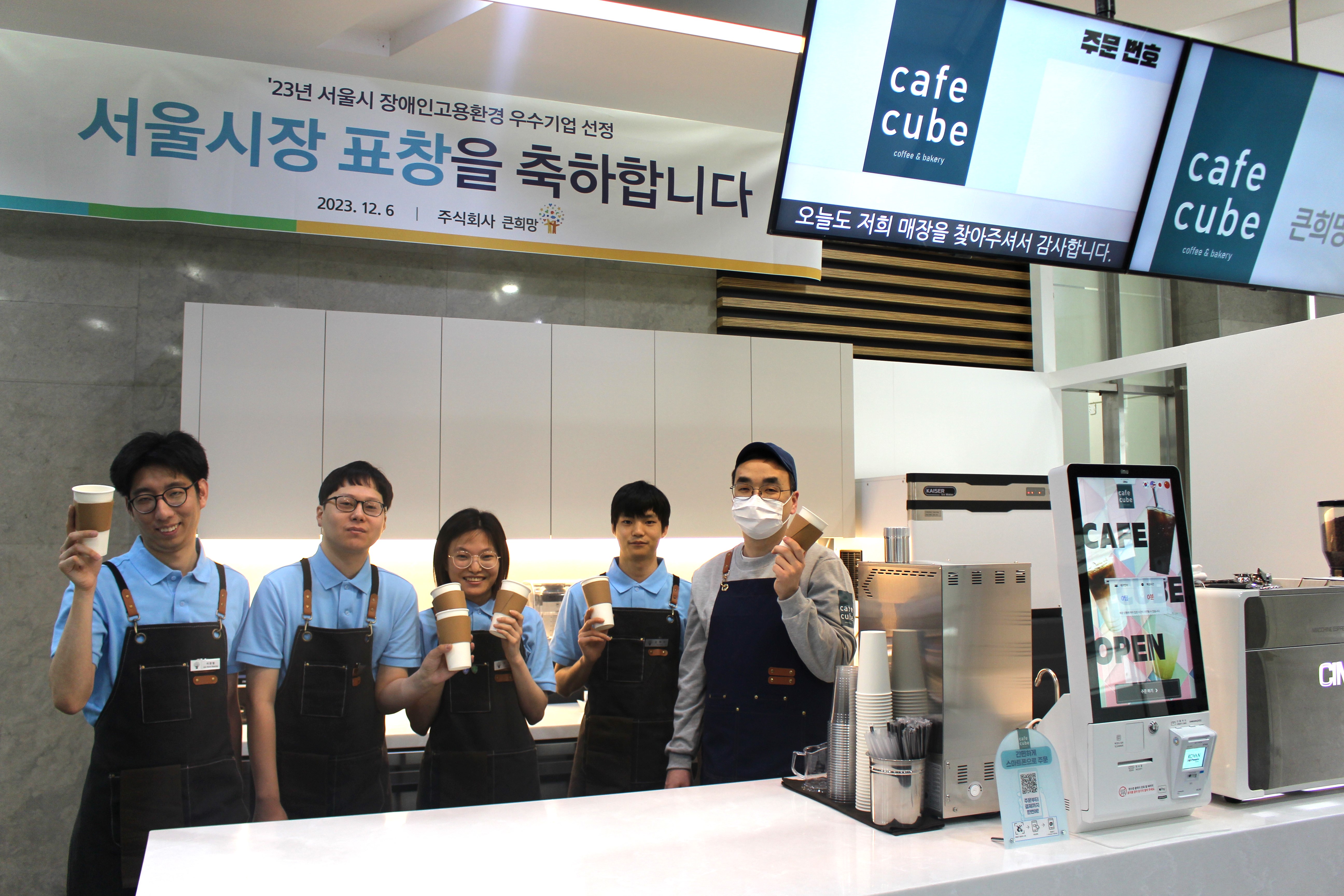 태광그룹 계열사 티시스는 장애인 바리스타가 근무하는 ‘카페큐브 영등포점’을 오픈했다고 26일 밝혔다. 카페큐브 영등포점 바리스타로 근무하게 된 티시스의 자회사형 장애인 표준사업장 ‘큰희망’ 직원들이 함께 웃고 있다. [사진=태광그룹 제공]