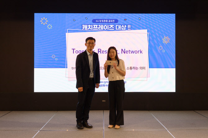 티알엔 한상욱 대표이사(사진 왼쪽)와 상호존중 슬로건 공모전 수상자 영업관리팀 김민정 사원이 기념촬영을 하고 있다. [사진=티알엔]