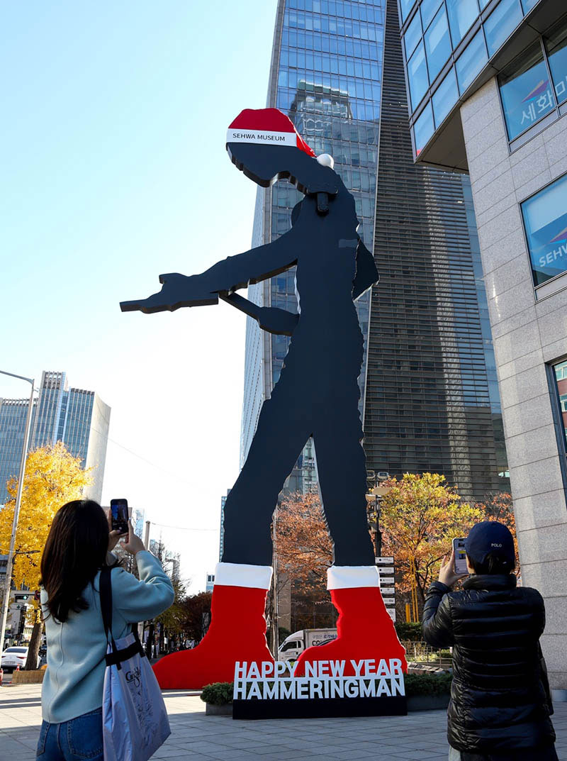 서울 광화문 랜드마크 <해머링맨 />이 산타 모자를 쓰고 빨간 양말을 신은 모습으로 25일 시민들에게 공개됐다. [사진=태광그룹]